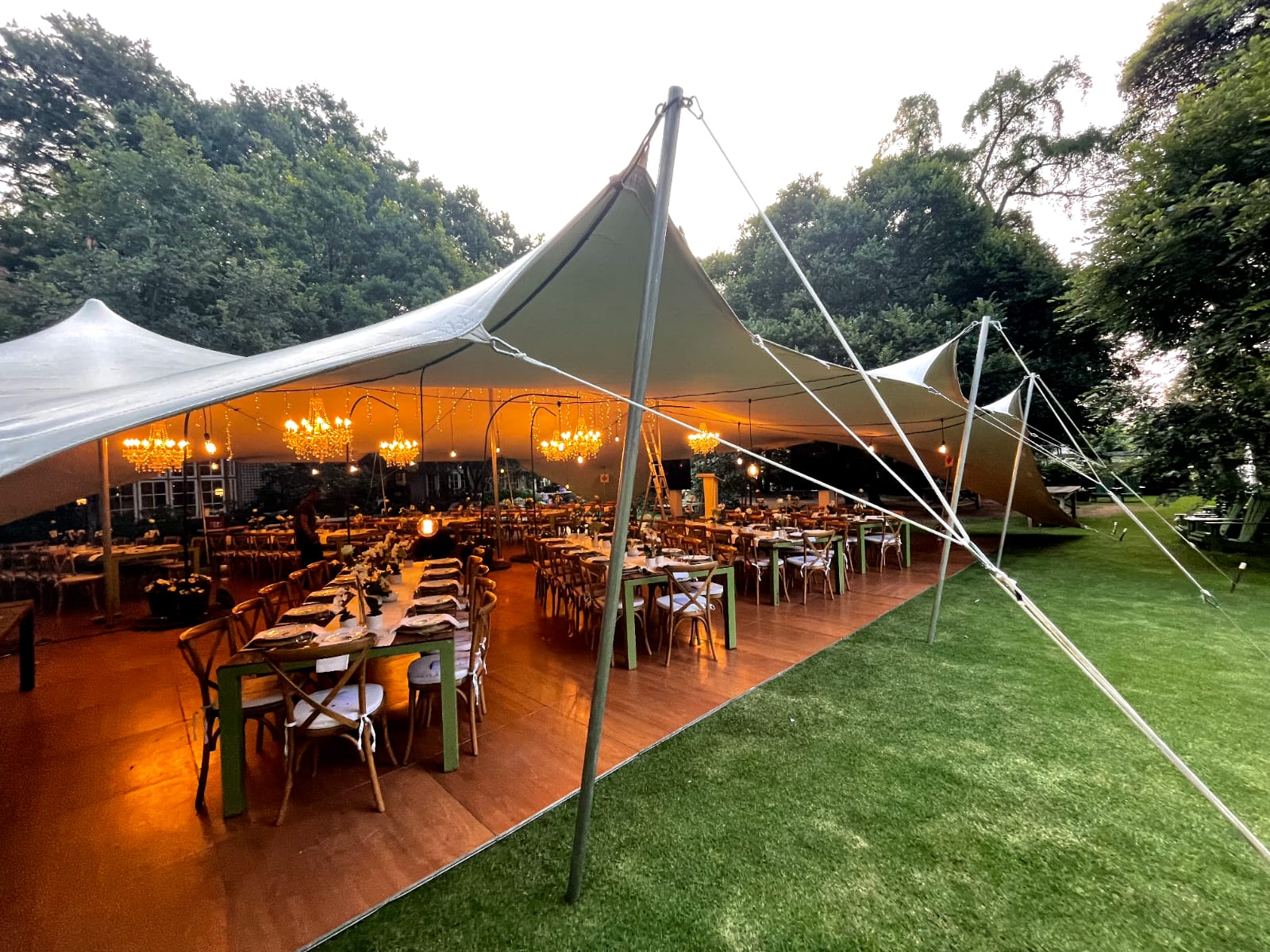 Stretch tent interior at night with warm chandelier lighting